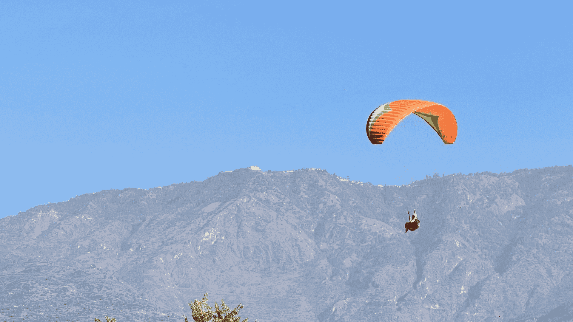 Snow-capped Pir Panjal range behind a paraglider near Manali