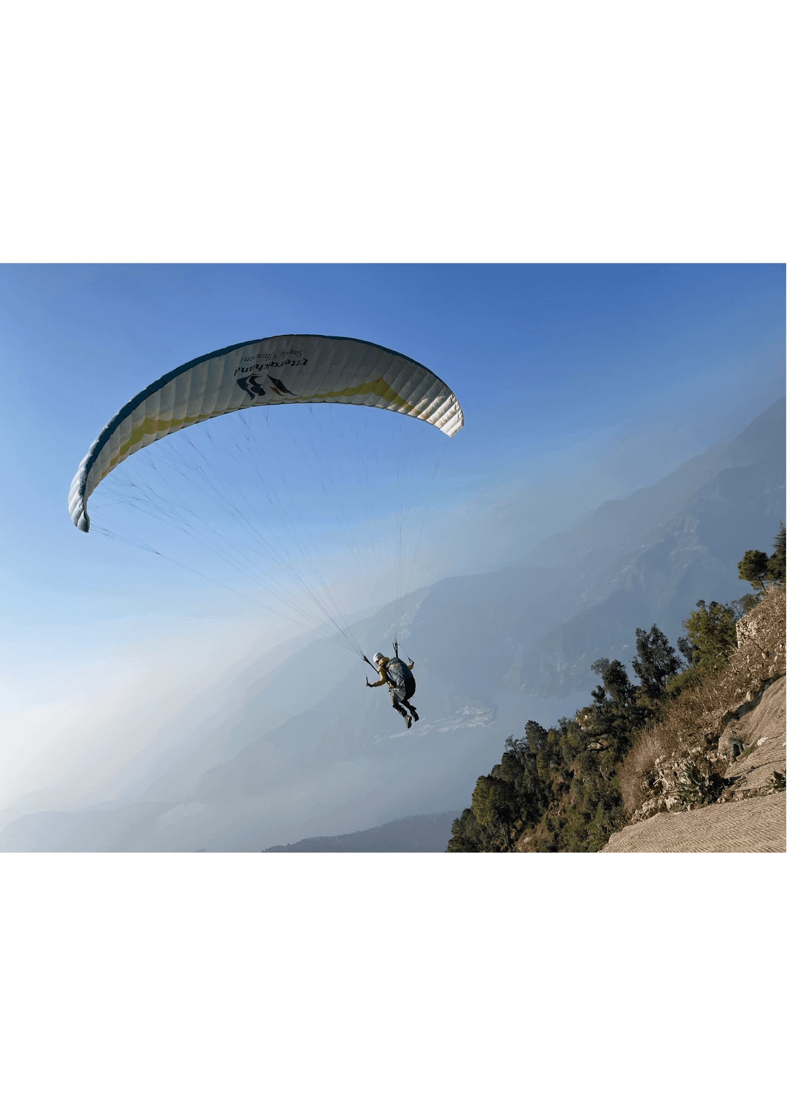 Paraglider over the rolling meadows of Vagamon, Kerala