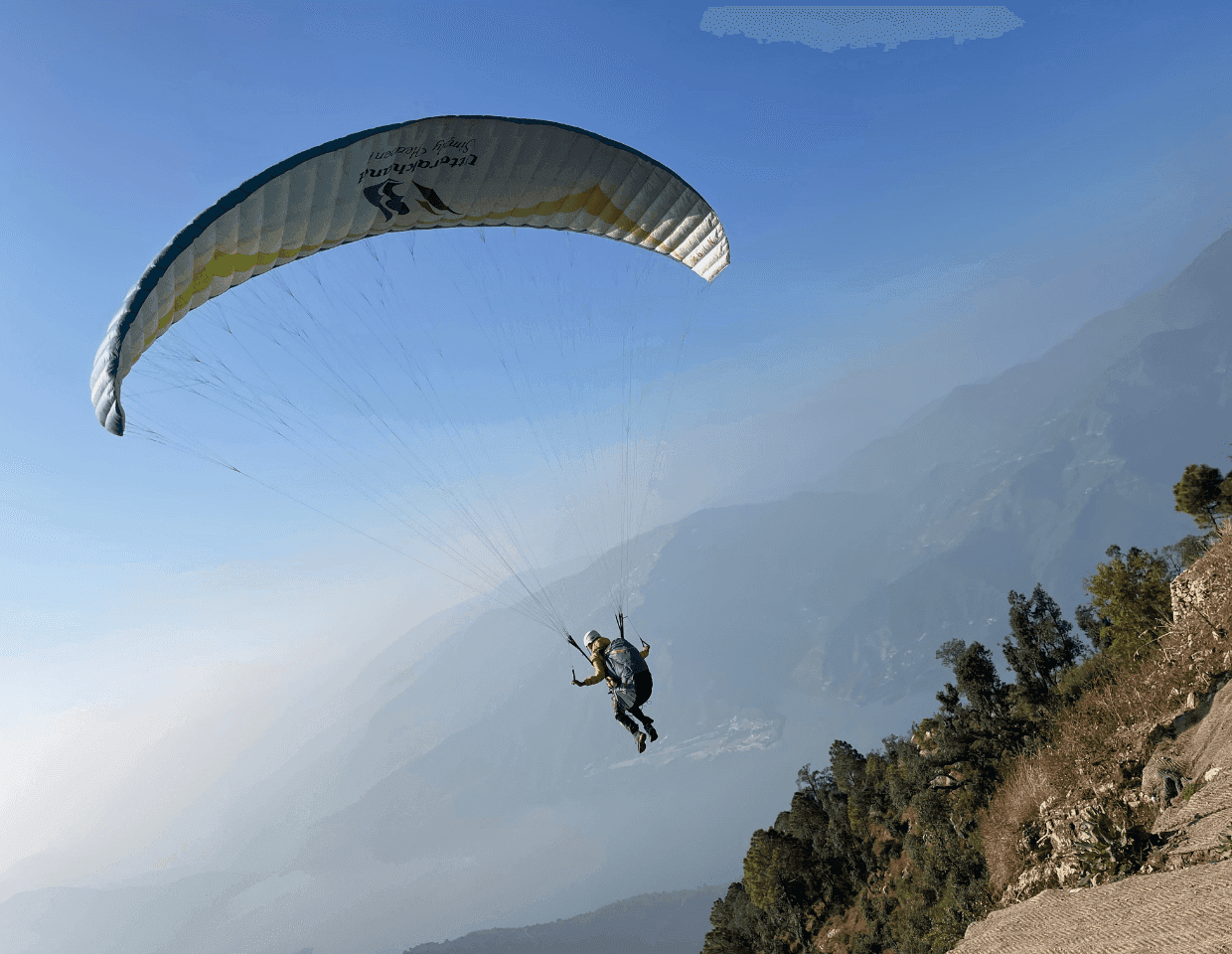 Paraglider over the lake basin at Naukuchiatal, Uttarakhand